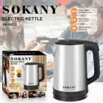Hervidor eléctrico Sokany SK-09022 de acero inoxidable con mango negro, base giratoria y capacidad de 2.3 litros, mostrado junto a su caja y personas compartiendo café en fondo desenfocado.