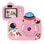 Cámara digital rosa para niños con temática espacial, astronauta y cohete en relieve, pantalla LCD frontal y lente central con texto HD 1080p.