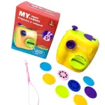 Cámara proyector y catapulta para niños en amarillo, con accesorios de colores y caja roja. Incluye correa y lentes intercambiables.