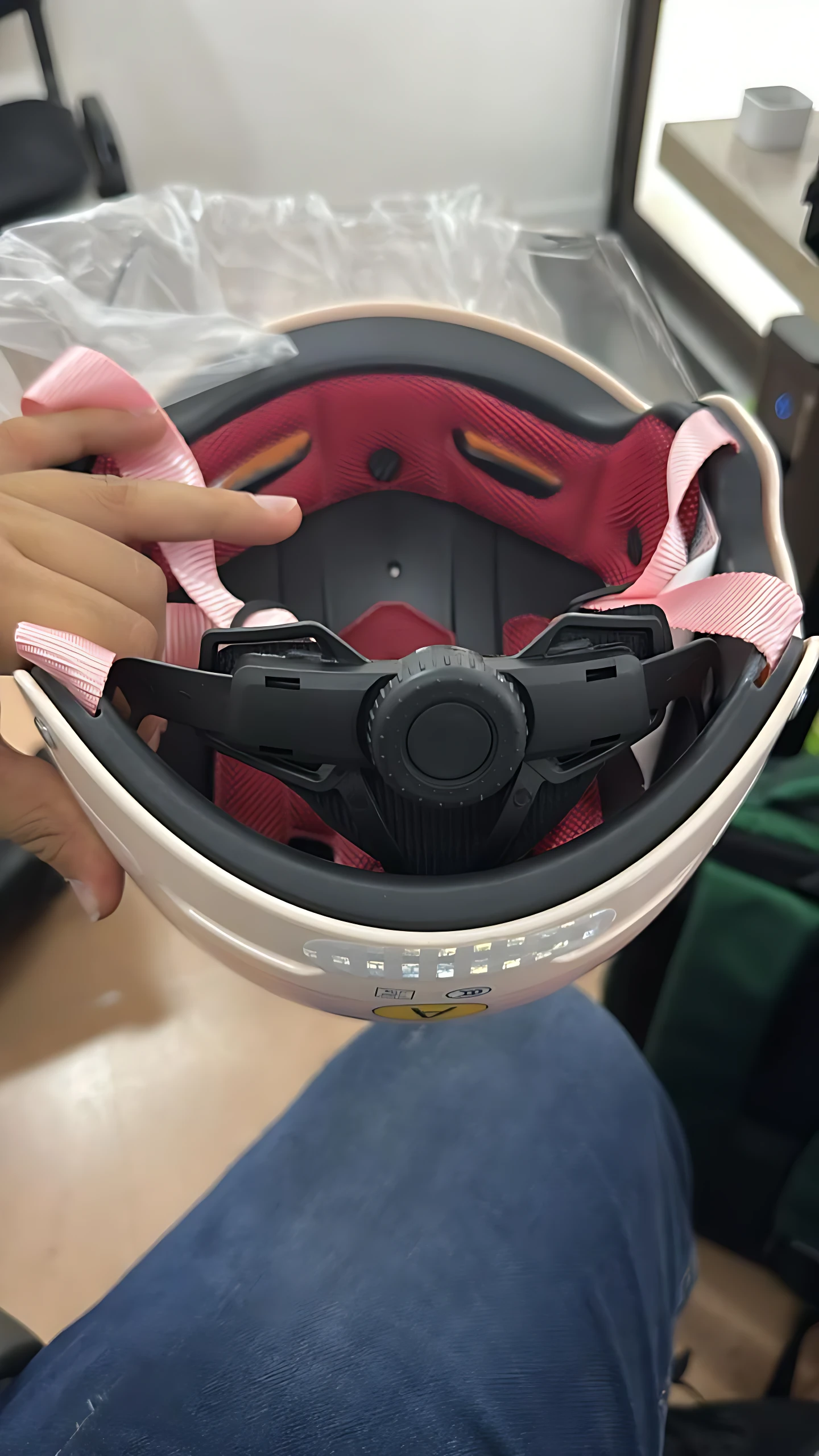 Casco juvenil Capibara KURSTUER color crema con visor extendido, interior rojo y correa rosa, mostrando sistema de ajuste central y detalles de protección facial.