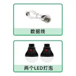 Contenido del paquete de lámpara C-Clamp CL-056: un cable USB blanco enrollado y dos bombillas LED negras con interruptor rojo, dispuestas lado a lado.