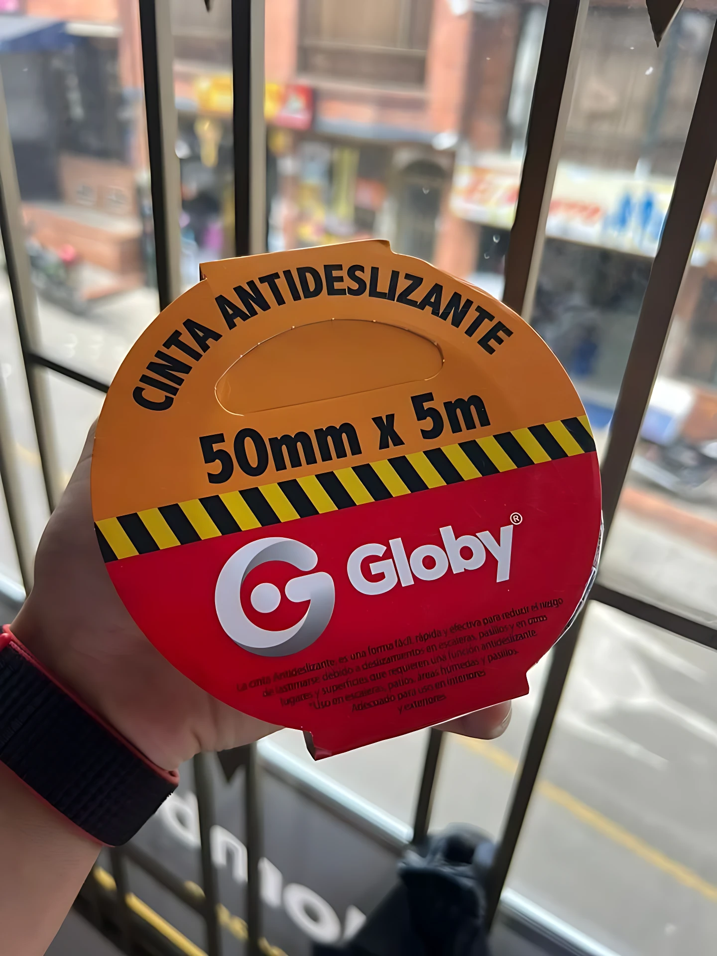 Cinta antideslizante Globy de 50mm x 5m, con diseño circular en naranja y rojo, textura mineral visible y logotipo central.
