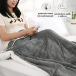 Cobija eléctrica gris con interior blanco, usada por mujer en cama; incluye control remoto y muestra protección contra sobrecalentamiento.