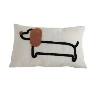 Cojín rectangular blanco con figura bordada de perro salchicha en negro y marrón, diseño minimalista para decoración de interiores.