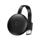 Dispositivo circular negro con logo C, conectado por cable USB-C, para proyectar contenido de celular a televisor sin cables.
