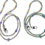 Dos correas de seguridad con cuentas artesanales, una en tonos lavanda y amarilla, la otra en azul claro y amarillo, ambas con cierre metálico y detalles decorativos.