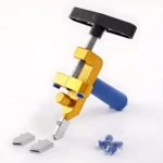 Cortador manual de baldosas con mecanismo de presión, cuerpo dorado y mango azul, incluye dos guías metálicas y accesorios en bolsa.