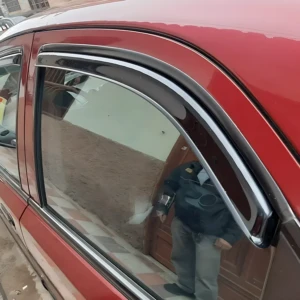 Deflector de ventana para auto rojo, con goma flexible y marco cromado, instalado en puerta lateral, bloquea lluvia y viento sin cerrar cristal.