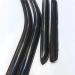 Cuatro deflectores de ventana negros con goma flexible, dispuestos en dos pares curvos y rectos sobre fondo blanco.