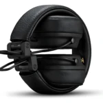 Diadema inalámbrica negra con cuero texturizado, vista lateral mostrando ajuste de orejeras y cable visible.
