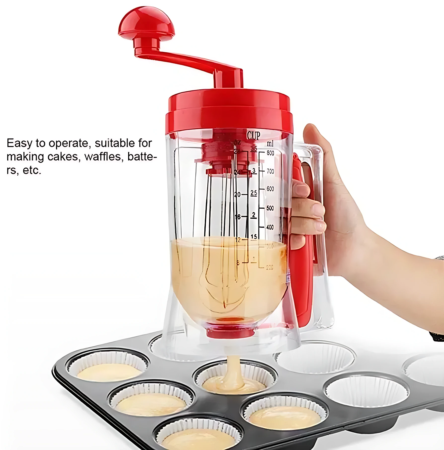 Dispensador de masa rojo con mango manual, llenando moldes para cupcakes con porciones iguales.