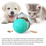 Dispensador interactivo para perros y gatos, color turquesa con tapa transparente, mostrando alimento derramado sobre superficie blanca.