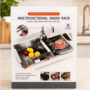 Escurridor de platos ajustable para fregadero, con rejilla metálica y soporte para frutas y verduras, sobre encimera blanca en cocina moderna.