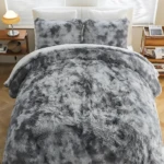 Edredón térmico peludo gris para cama doble, con textura suave y voluminosa, sobre cama con almohadas y mesitas de noche.