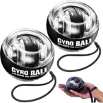 Dos ejercitadores de brazo Gyro Ball en color negro con detalles plateados, mostrando su estructura interna giratoria y correa de sujeción. Incluye vista en mano para demostrar tamaño y uso.