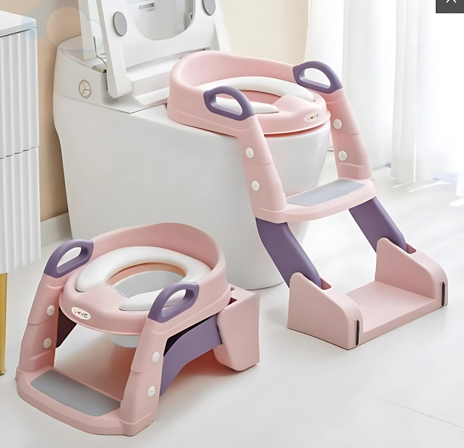Escalera de baño plegable en rosa y morado, con asideros y escalones antideslizantes, diseñada para facilitar el uso del inodoro en niños.