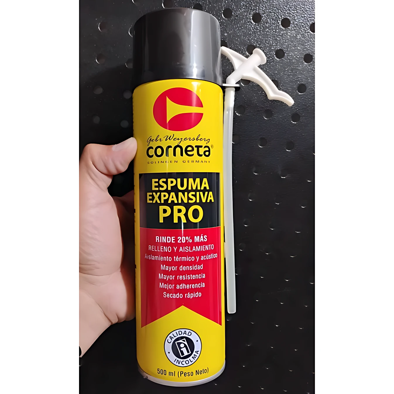 Espuma expansiva Corneta Pro en lata amarilla con mango blanco, sobre fondo negro perforado. Etiqueta con detalles técnicos y logotipo visible.