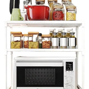 Estante blanco de tres niveles con horno microondas en la base, organizador de cocina con tarros de especias y utensilios en los estantes superiores.