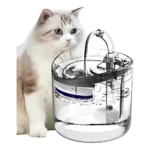 Fuente de agua para gatos con diseño transparente y mecanismo interno visible, acompañada de un gato blanco y gris observando el dispositivo.