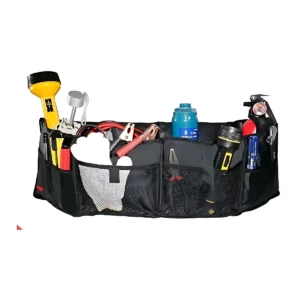Organizador negro para baúl de camioneta con múltiples compartimentos, mostrando herramientas, botella azul, linterna amarilla y otros accesorios dispuestos en sus bolsillos.