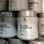 Varios frascos de Gel Moldeador Corporal Corps Lignea con Crioterapia y Mentol, presentados en tonos beige y plateado, apilados en estantería.