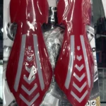 Cortavientos rojo con luces LED integradas, diseño ergonómico con detalles en blanco, empaquetado para manillares de motocicleta.