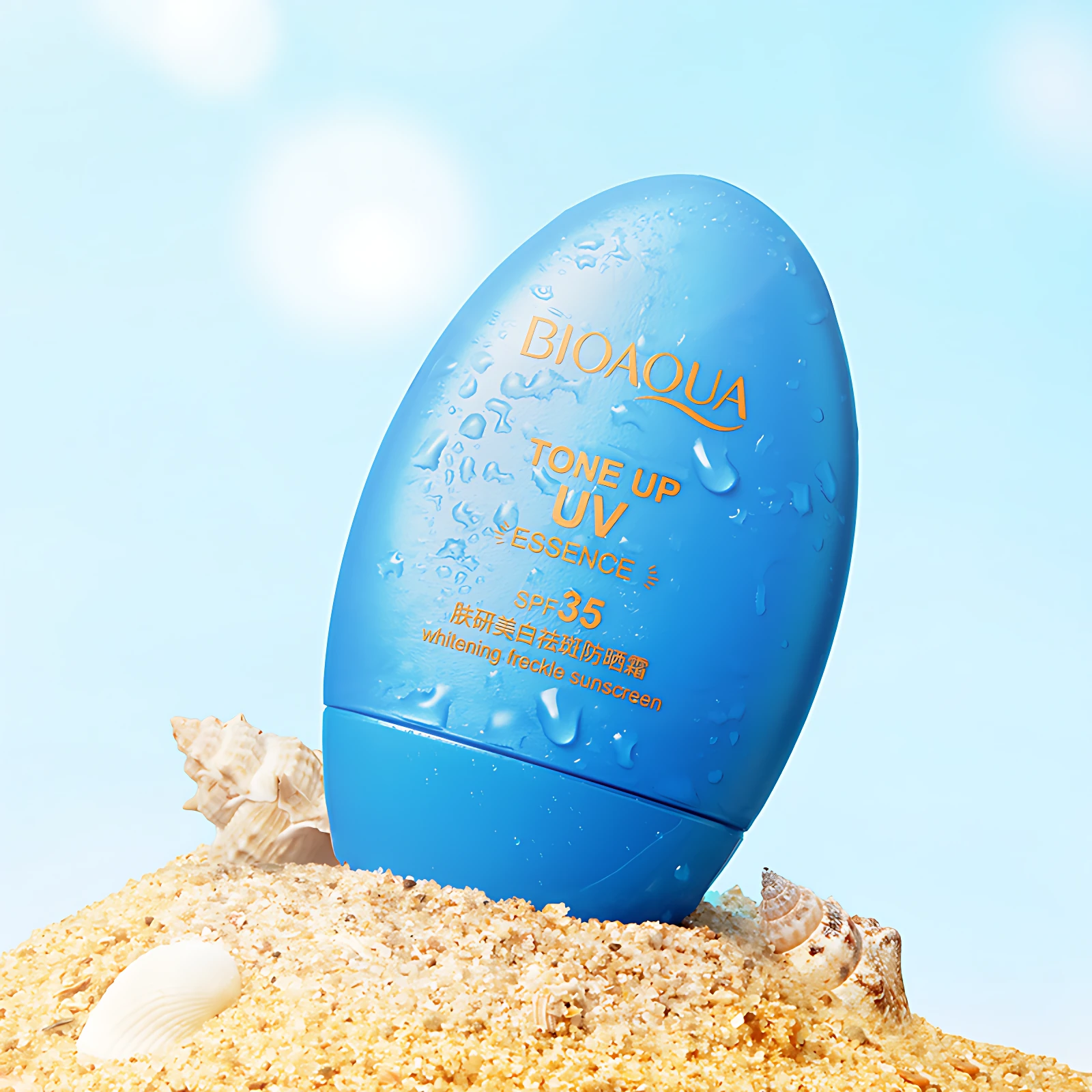 Bloqueador solar BIOAQUA en envase azul brillante con gotas de agua, sobre arena y conchas, SPF 35, tono up, protección UV.