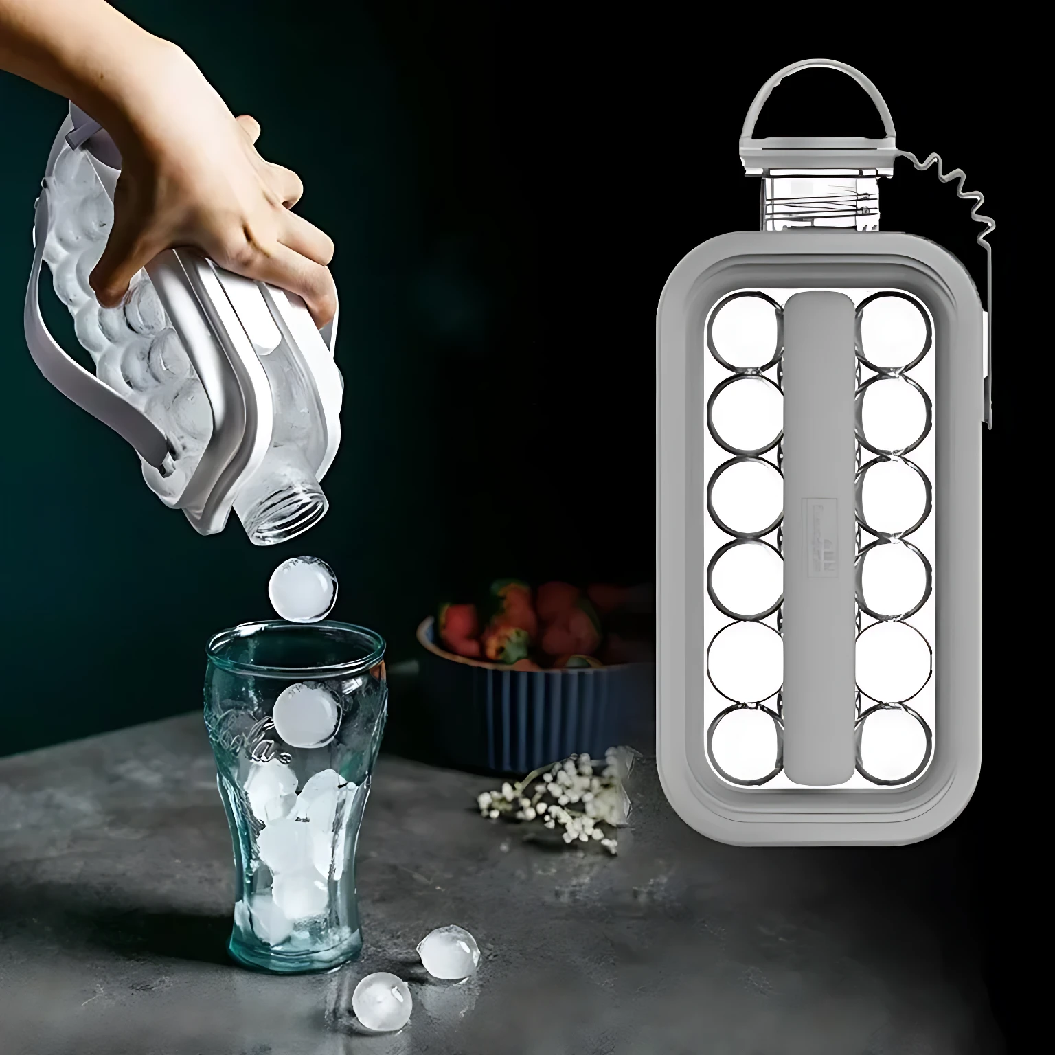 Hielera portátil en uso: mano vierte bolas de hielo de un molde flexible blanco a vaso transparente sobre mesa oscura con frutas al fondo.