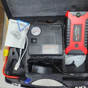 Iniciador de carro rojo y negro con power bank integrado, compresor de aire, cables de arranque, medidor de presión y accesorios en maleta de transporte.