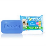Barra de jabón Pompas azul con logotipo grabado, junto a su empaque de 75 g que incluye perros y gatos, con protección contra pulgas y garrapatas.