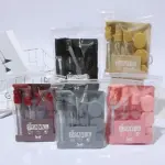 Set de tres organizadores transparentes para líquidos de viaje, en colores rojo, negro, gris y rosa, con tapas y etiquetas que indican TRAVEL.