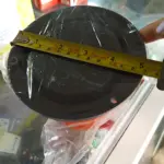 Licuadora inmantada negra con cinta métrica mostrando diámetro de 15 cm, sobre mostrador de tienda.