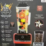 Licuadora eléctrica RAF de 2.5 litros con base roja y jarra transparente llena de frutas, incluye cuchillas de acero inoxidable y panel de control digital.