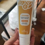 Tubo de gel corporal exfoliante despigmentante de la marca Cosmof, con diseño en tonos naranja y blanco, mostrando el nombre del producto y su función principal en la etiqueta frontal.