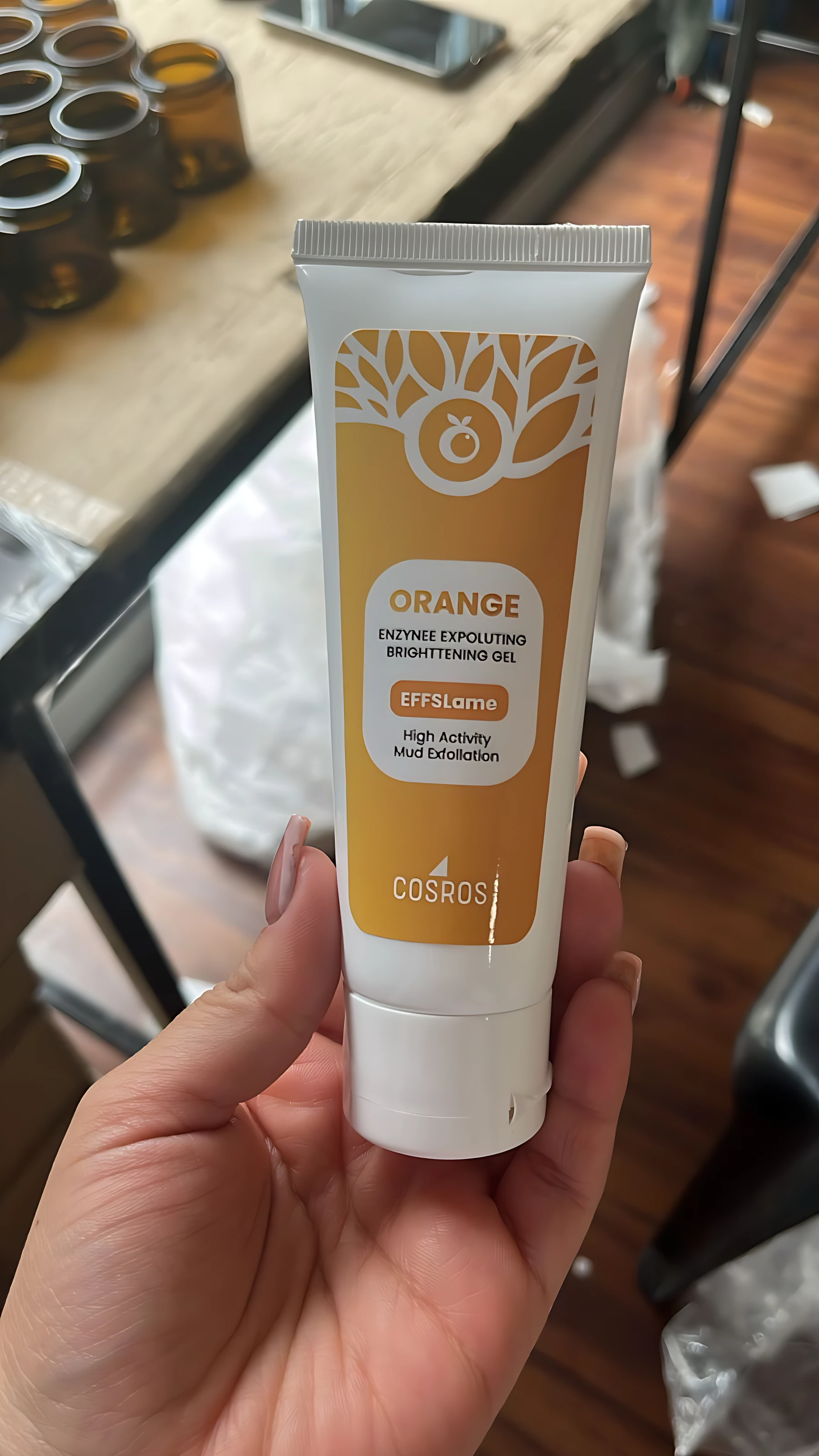 Tubo de gel corporal exfoliante despigmentante de la marca Cosmof, con diseño en tonos naranja y blanco, mostrando el nombre del producto y su función principal en la etiqueta frontal.