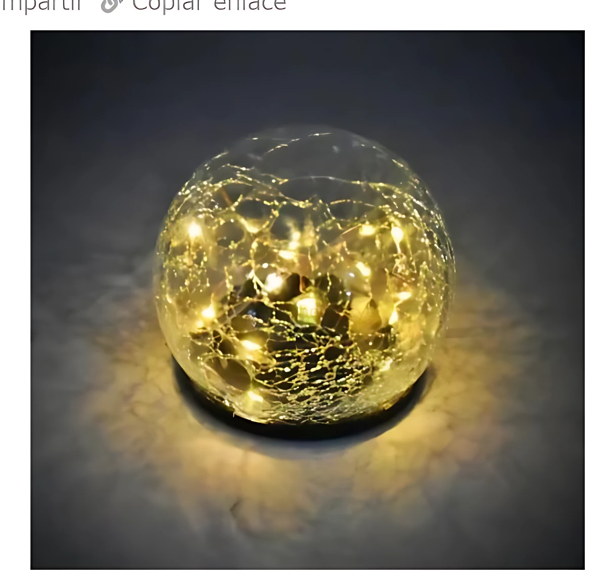 Esfera decorativa de cristal con textura agrietada, iluminada por luces LED cálidas, sobre superficie oscura.