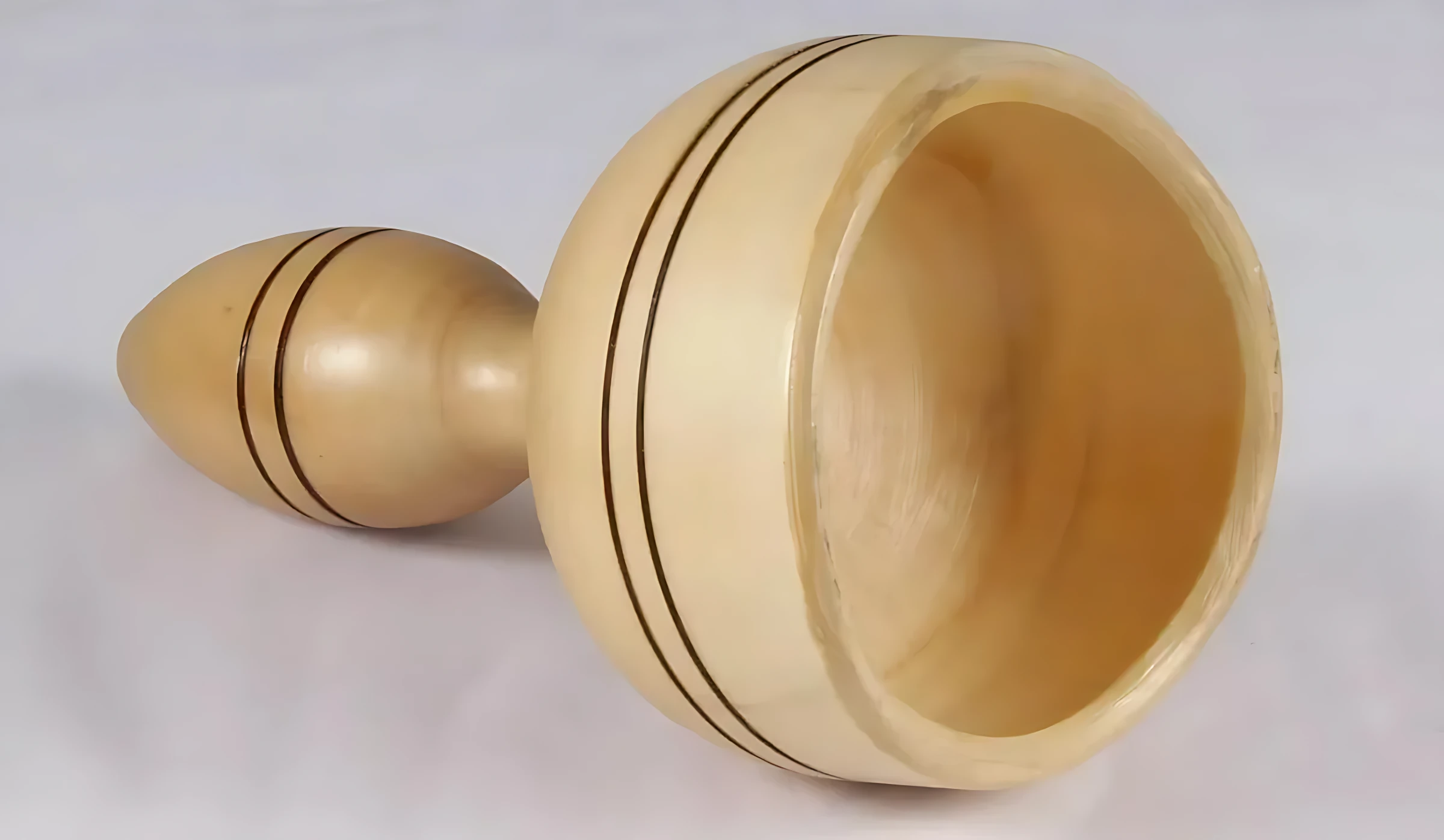 Copa sueca de maderoterapia ergonómica en madera clara con detalles en negro, vista lateral mostrando su forma ovalada y textura pulida.