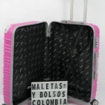 Maleta rígida rosa abierta mostrando interior negro con patrón repetitivo, ruedas giratorias y asa telescópica extendida.