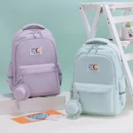 Mochila escolar Jiaheng en tonos lavanda y menta, con compartimento para portátil 15.6 pulgadas y accesorios colgantes.