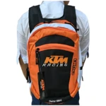 Mochila KTM Racing en naranja y negro, vista trasera con logo frontal y etiqueta colgante. Ideal para uso deportivo o urbano.