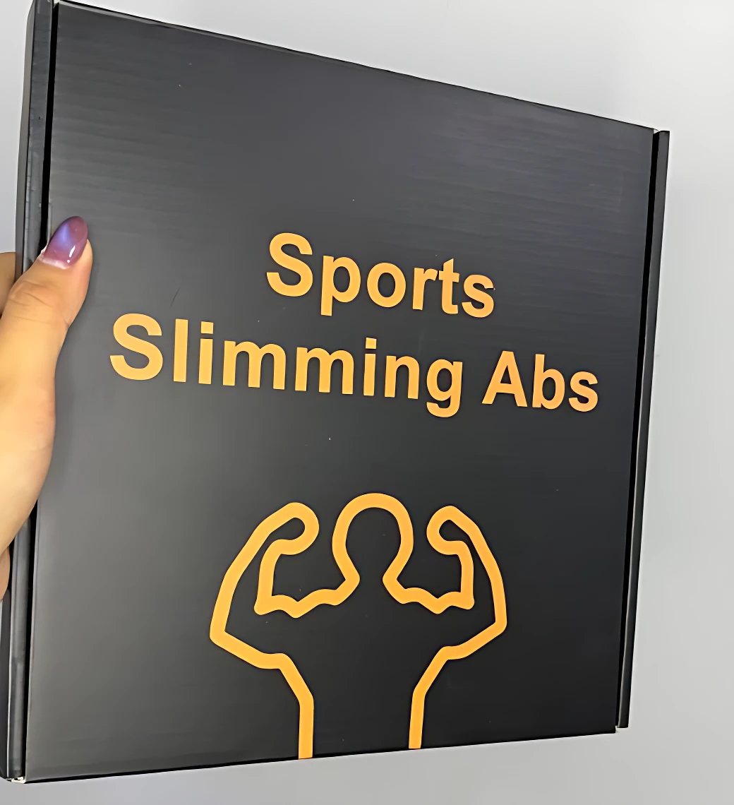 Caja negra con texto amarillo que dice Sports Slimming Abs y un dibujo de brazos flexionados, mostrando el empaque del masajeador escultor EMS para tonificar abdomen y brazos.