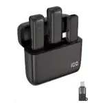Cargador de batería para micrófonos inalámbricos, color negro mate. Muestra dos micrófonos finos en posición vertical dentro de la base, con indicador LED encendido y pantalla digital mostrando "100". Incluye adaptador Lightning visible en primer plano.