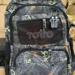 Mochila escolar juvenil tipo Totto con diseño geométrico en tonos oscuros, detalles en verde y naranja, compartimentos frontales con cremalleras y logotipo visible.