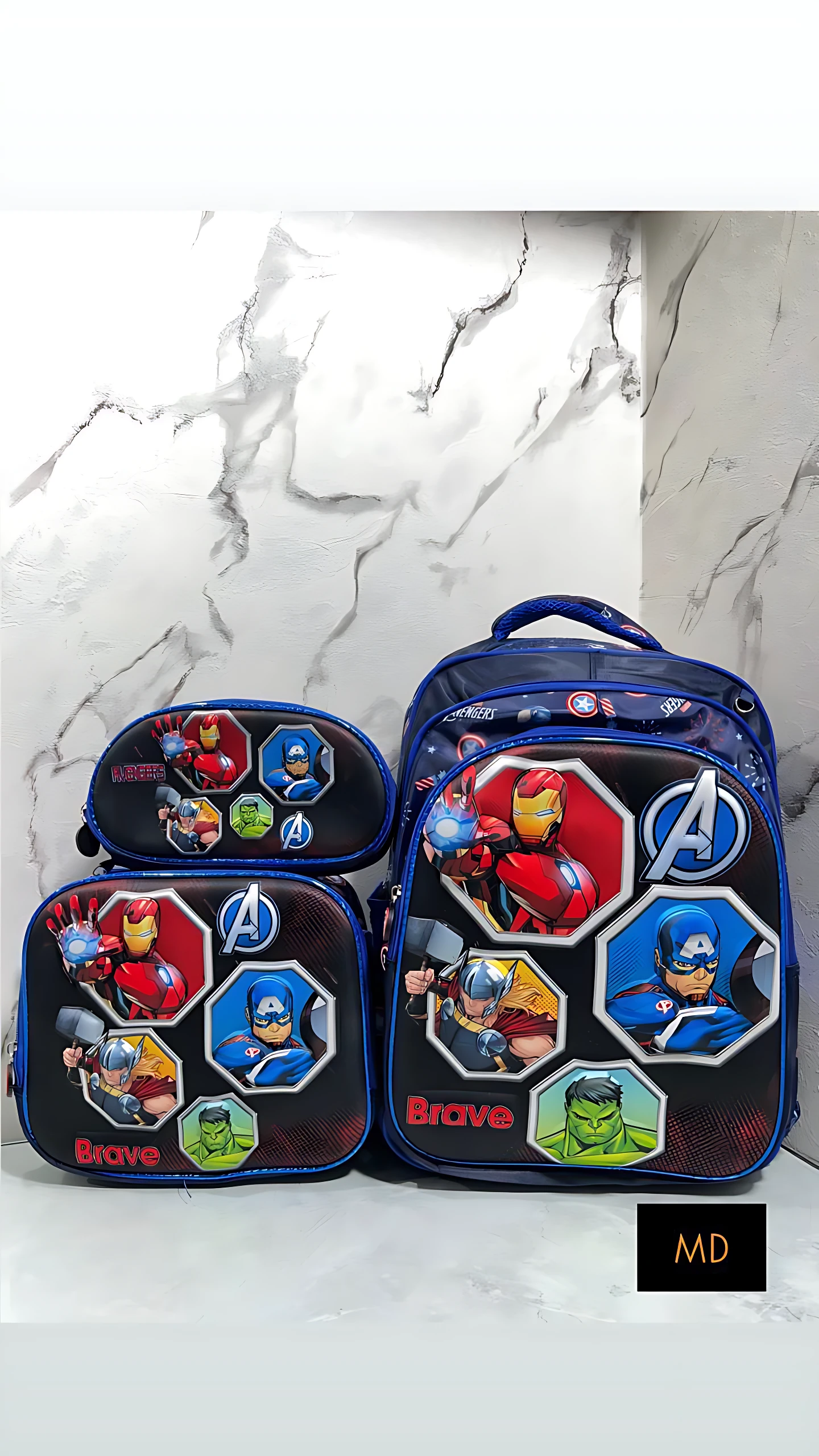 Morral escolar azul con personajes de los Vengadores, incluye lonchera térmica y estuche para útiles, diseño con relieve y logotipos visibles.