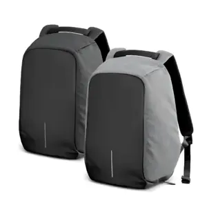 Dos morrales impermeables antirrobo; uno completamente negro y otro gris con frente negro, ambos con diseño minimalista, asa superior y puerto USB visible.