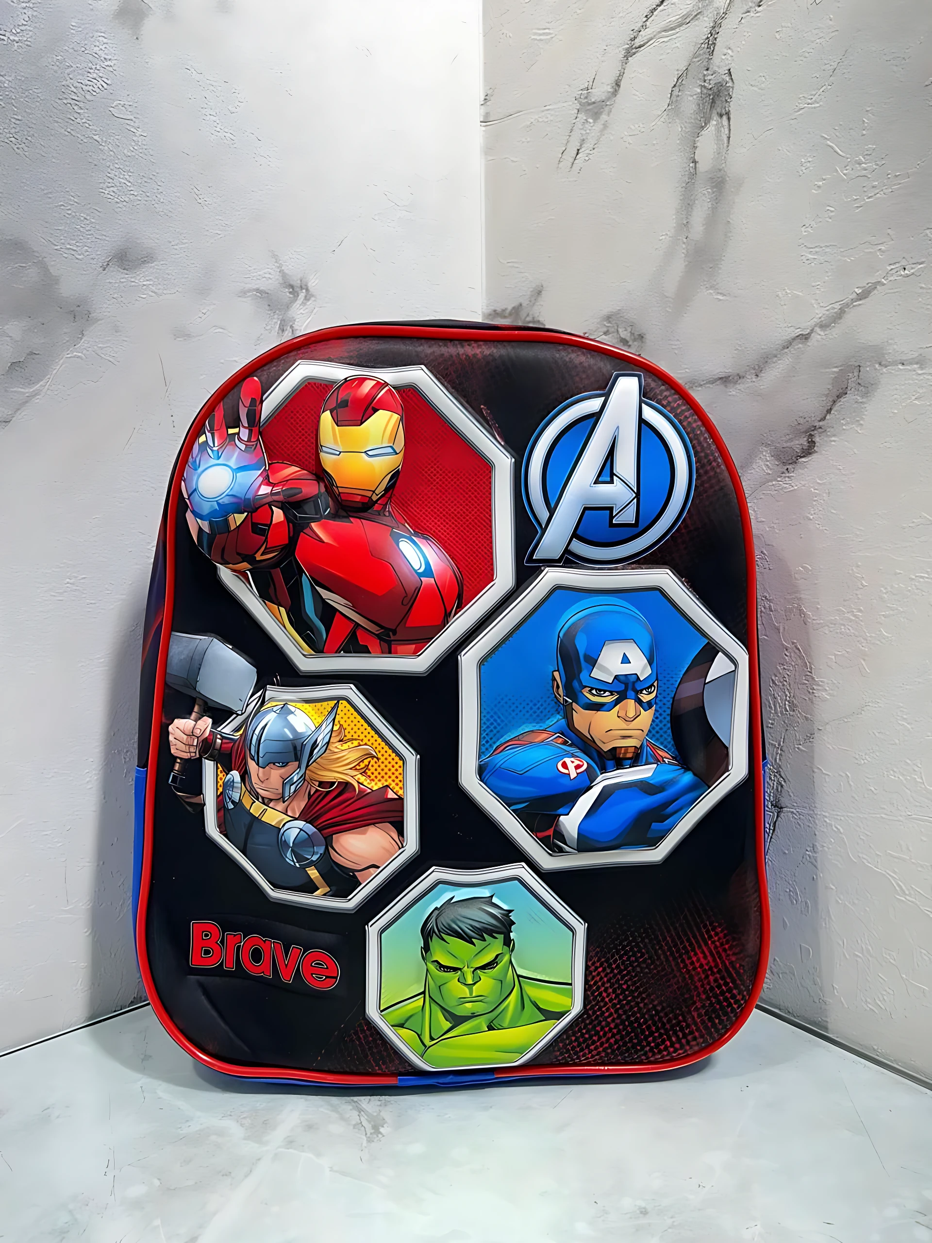 Mochila escolar infantil compacta con cierre único, diseño Avengers con personajes Iron Man, Thor, Capitán América y Hulk sobre fondo negro con bordes rojos.