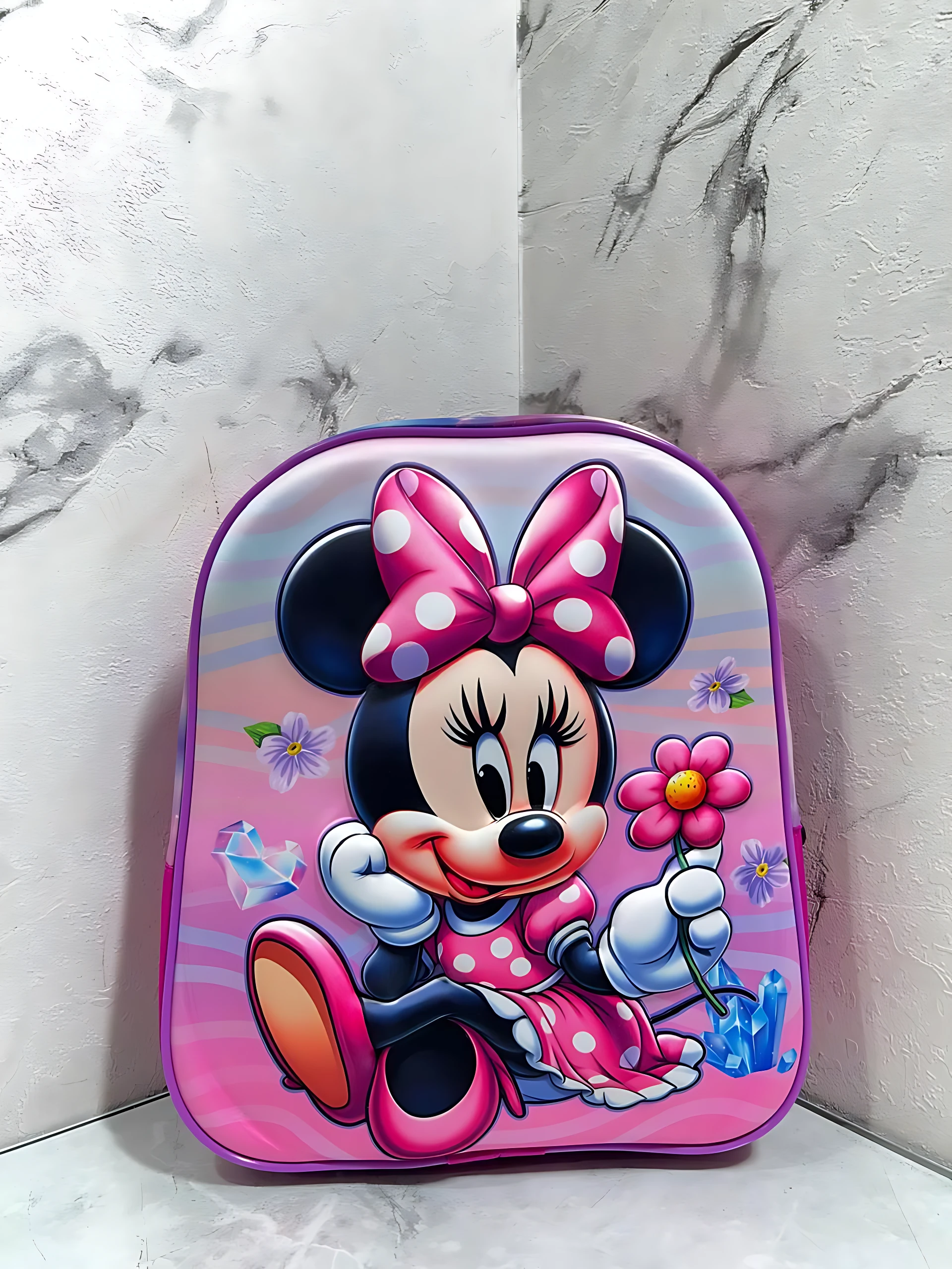 Mochila escolar infantil compacta con cierre único, diseño de Minnie Mouse en tonos rosados y morados, con detalles de flores y diamantes.