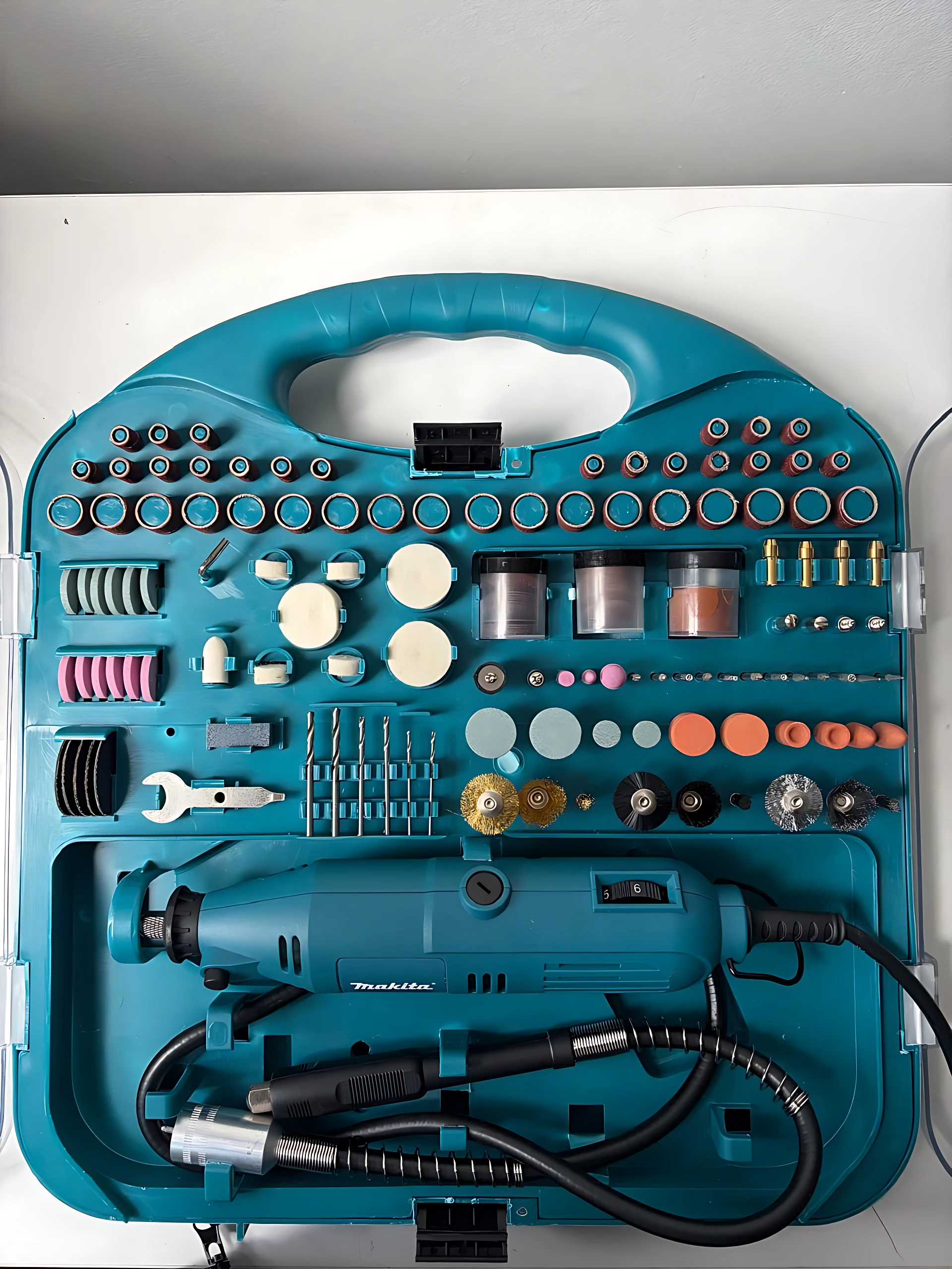 Makita motortool de alta velocidad en estuche azul con accesorios organizados para desbaste y pulido en espacios reducidos.