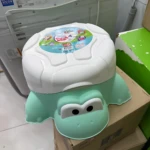Orinal para bebé en forma de tortuga, color verde menta con tapa blanca. Diseño amigable con ojos grandes y caparazón decorado. Ideal para entrenamiento en control de esfínteres.
