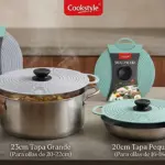 Set de dos tapas universales en silicona, una de 23 cm y otra de 20 cm, con asas negras y diseño circular, mostradas junto a ollas y recipientes.